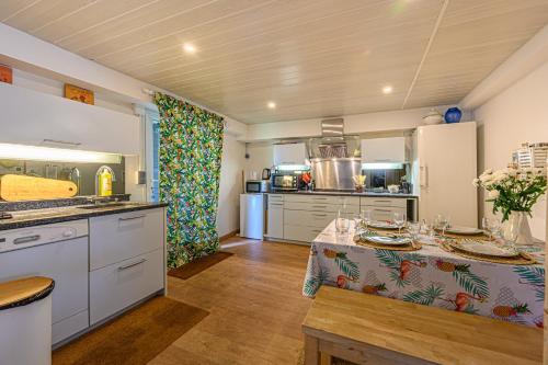une cuisine avec une table recouverte d'une nappe dans l'établissement Sous les Palmiers - Charmant Appartement avec terrasse, à Vannes