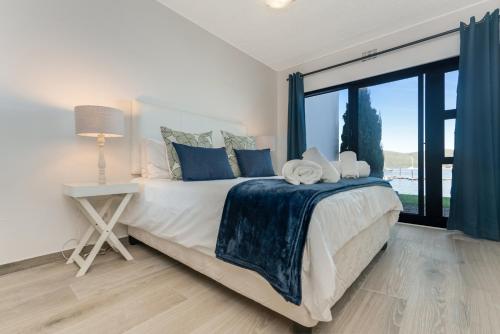 a bedroom with a large bed and a large window at Vista Laguna in Knysna