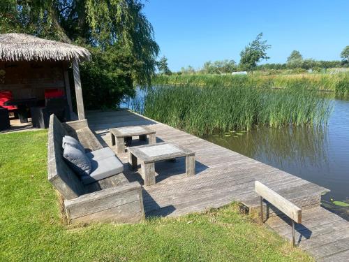 een houten dock met banken, een tafel en een hut bij Wetterwillefriesland in Wommels