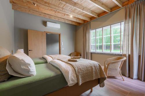 Schlafzimmer mit einem Bett mit einem Tisch und einem Fenster in der Unterkunft Hulstehof in Zarren