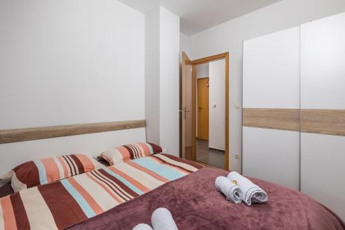 - une chambre avec un lit et des serviettes dans l'établissement Nora, à Mrkopalj