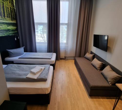 a hotel room with two beds and a tv at Novitel Hotel Kirchheim - München Messe in Kirchheim