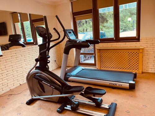 a room with a gym with a treadmill and a laptop at Grand Hotel Pylypets in Pilipets