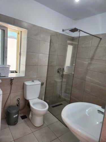 a bathroom with a shower and a toilet and a sink at Cosy guest house in Sarandë