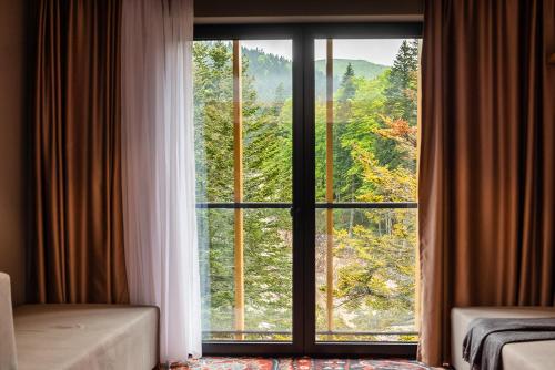 a room with a window with a view of a forest at Hotel Nomad in Bjelašnica