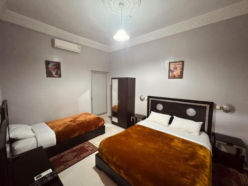 una habitación de hotel con 2 camas en una habitación en Hôtel Narjisse en Marrakech