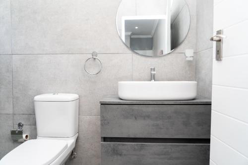 W łazience znajduje się toaleta, umywalka i lustro. w obiekcie Starfish Cottage, Langebaan w mieście Langebaan