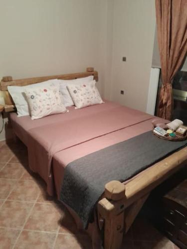 a bedroom with a wooden bed with a tray on it at Villa Nestor in Platamonas