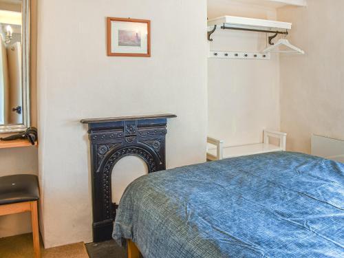 a bedroom with a bed and a fireplace at Tyn Y Berth in Talsarnau