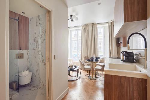 a kitchen with a sink and a table in a room at Apart hotel Centre de Paris by Studio prestige in Paris