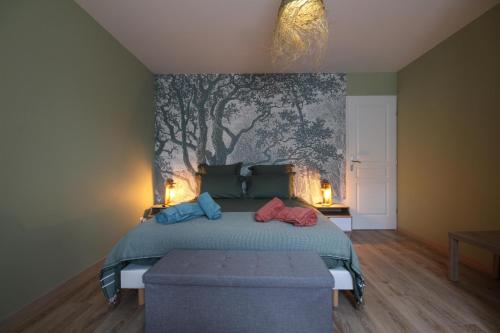 a bedroom with a bed with a painting on the wall at Gîte de Savenay in Aunay-en-Bazois