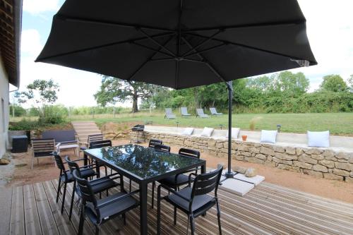 a table and chairs with an umbrella on a deck at Gîte de Savenay 