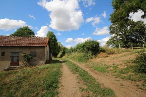 a dirt road next to a house on a field at Gîte de Savenay in Aunay-en-Bazois
