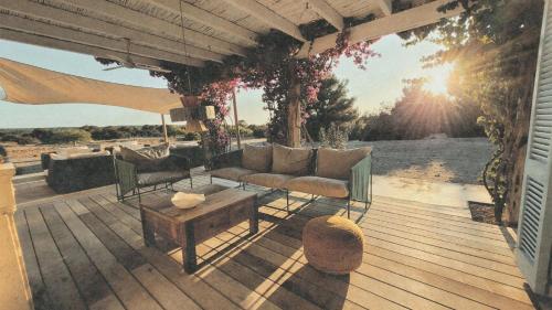 a patio with a couch and a table on a deck at CASA MAGALI in Sant Francesc Xavier