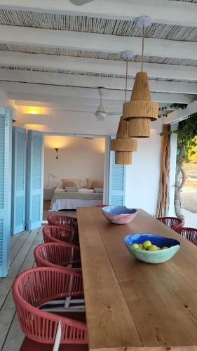 a dining room with a wooden table and red chairs at CASA MAGALI in Sant Francesc Xavier