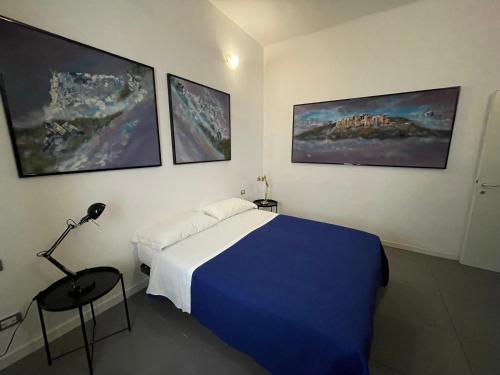 a bedroom with a bed and three paintings on the wall at Milano Canal Apartments in Milan