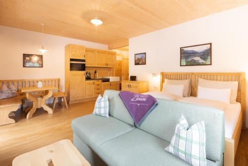 a bedroom with a bed and a couch and a table at Narzissendorf Zloam Apartments in Grundlsee