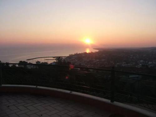 a sunset over a city with the sun setting in the distance at Villa Nestor in Platamonas