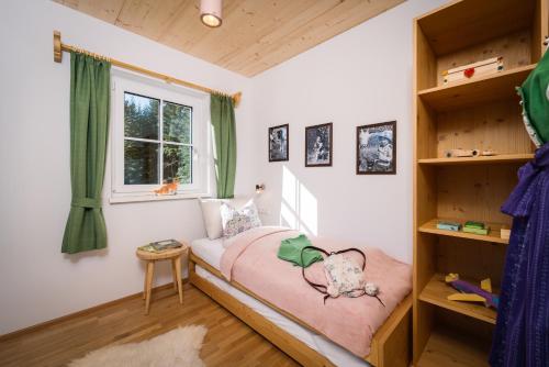 um pequeno quarto com uma cama e uma janela em Narzissendorf Zloam Apartments em Grundlsee