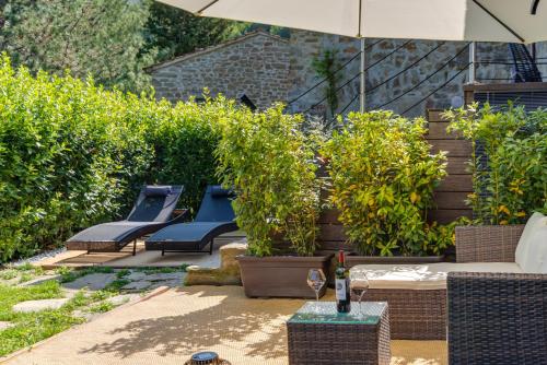 a patio with blue benches and trees and an umbrella at Luxury Country Retreat La Stallina in Londa
