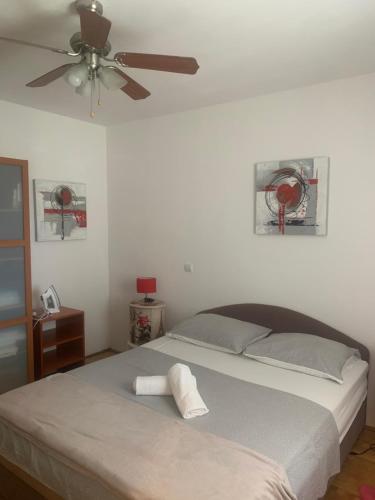 a bedroom with a bed with a ceiling fan at Apartman S & S in Makarska