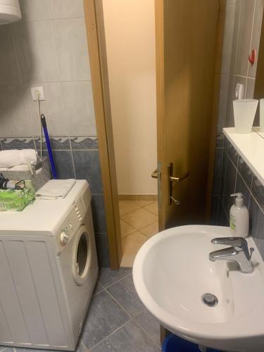 a bathroom with a washing machine and a sink at Apartman S & S in Makarska