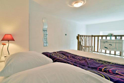 une chambre avec deux lits, une table et une lampe dans l'établissement Le Sillon - Appartement proche de la plage, à Saint-Malo