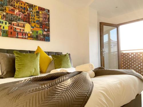 Schlafzimmer mit einem Bett mit Wandgemälde in der Unterkunft Spacious 3 bed 3 bath Duplex Apartment - 18 mins from Central London - Sleeps 8 in Watford