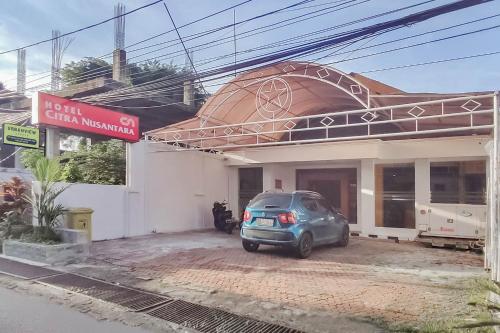 a car parked in a parking lot in front of a building at Hotel Syariah Citra Nusantara Balikpapan in Klandasan Kecil