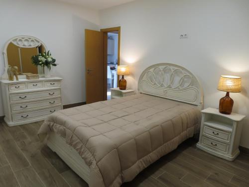 1 dormitorio con cama, tocador y espejo en Casal do Zé 
