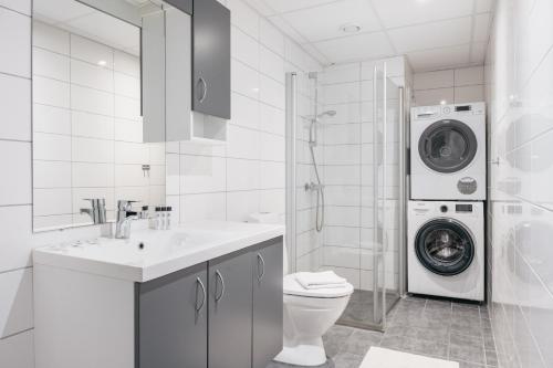 a bathroom with a washing machine and a washer at Nordic Nights: 3BR with Balcony in Bergen