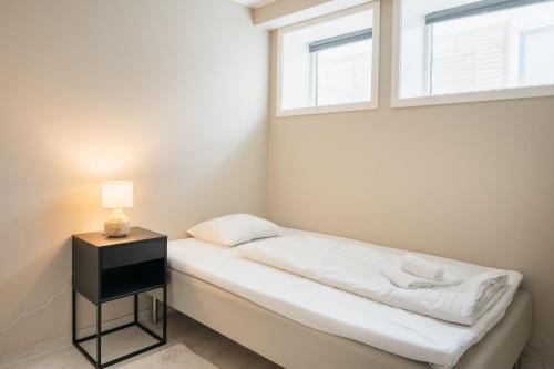 ein kleines Schlafzimmer mit einem Bett und einem Fenster in der Unterkunft Nordic Nights: 3BR with Balcony in Bergen