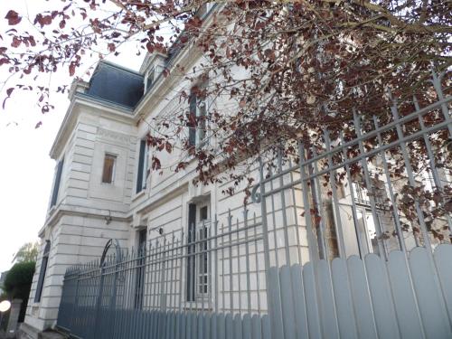 uma casa branca com uma cerca à frente. em La Maison Blanche - AppartHôtels climatisés de charme Chic & Cosy - Centre-ville em Limoges