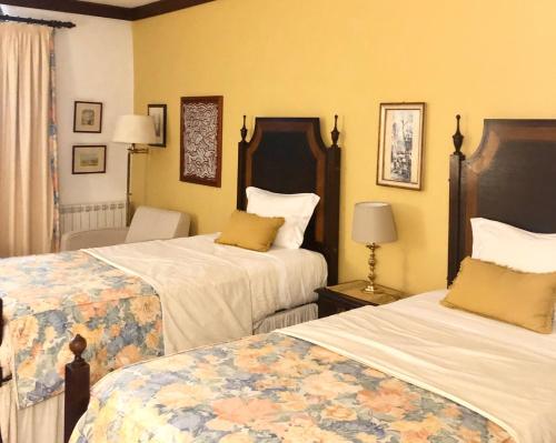 een hotelkamer met 2 bedden en een stoel bij Casa Das Obras in Manteigas
