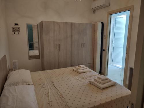 a bedroom with a bed with three towels on it at Sal y Mar in Torre San Giovanni Ugento