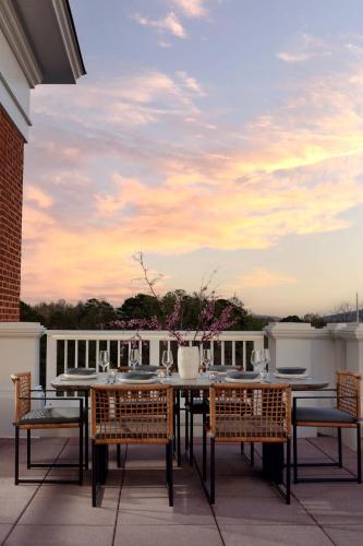 a patio with a table and chairs on a roof at Kimpton - The Forum Hotel by IHG in Charlottesville