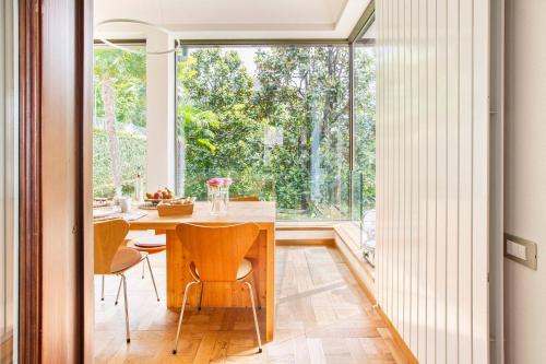 a dining room with a table and a large window at Villa Noseda in Moltrasio