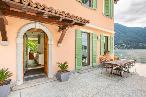 a house with a patio with a table and chairs at Villa Noseda in Moltrasio