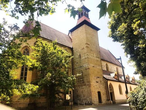 Una vieja iglesia con un campanario encima. en Szafranzimmervermmitung, en Winnenden