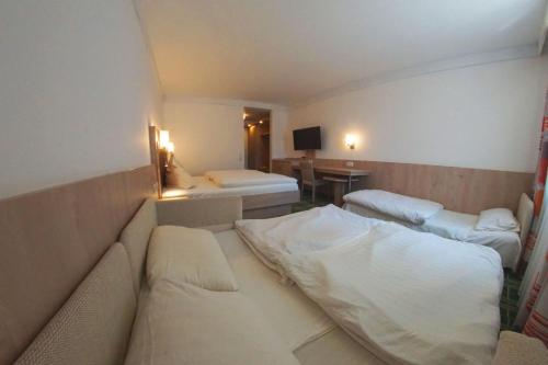 a hotel room with two beds and a desk at Gasthof zum Bayerischen in Greding