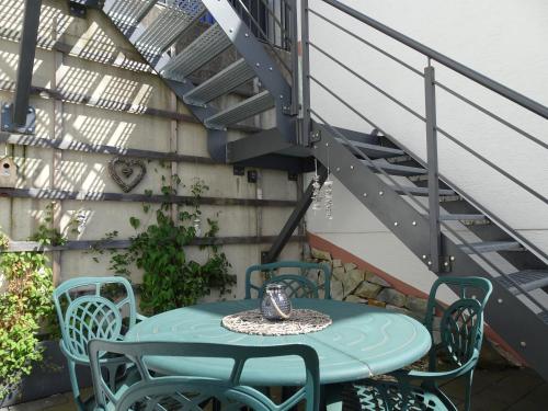 a table and chairs on a patio with a staircase at Ferienwohnung Büren-Harth in Büren