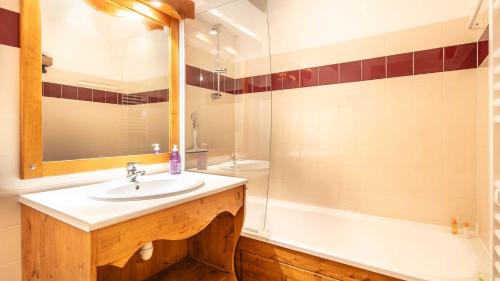 une salle de bain avec un lavabo et une baignoire dans l'établissement V du Bachat Arolles A03 - Appt 4 pers, à Chamrousse