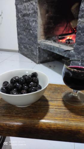 a bowl of blackberries next to a glass of wine at Friendly House in Akhaltsikhe