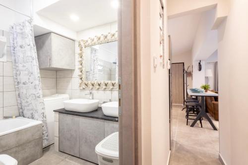 Rafina Bay Breeze في رافينا: حمام مع حوض وحوض استحمام ومرحاض