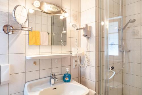 uma casa de banho com um lavatório e um chuveiro em Ferienwohnung - Hexi em Bad Kohlgrub