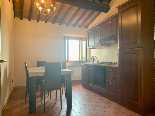cocina con mesa y sillas y cocina con ventana en Caratteristico appartamento nel borgo medievale en Castiglione della Pescaia