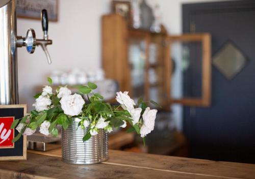 a metal vase with white flowers on a table at Agriturismo La Terrazza su Farfa in Castelnuovo di Farfa