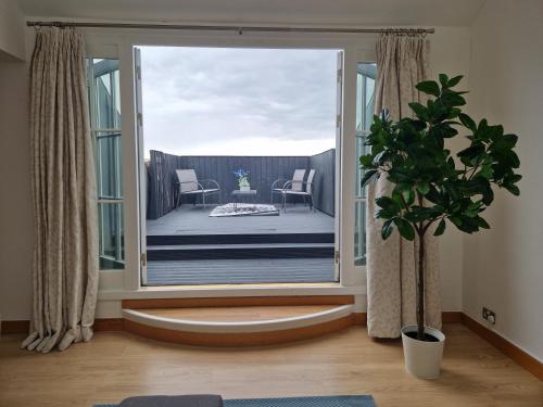 ein Wohnzimmer mit einer großen Glastür zu einem Balkon in der Unterkunft Weekly & Monthly stays in Penthouse for Contractors or Leisure Single or Superking beds available in Birkenhead