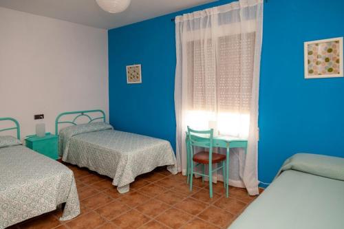 Cette chambre comprend 2 lits, une table et une fenêtre. dans l'établissement Los olivares de Rober, à Polán