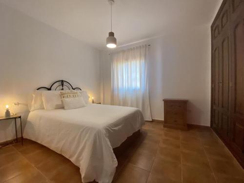 una camera con un letto bianco e una finestra di V V El Cantil a Valverde